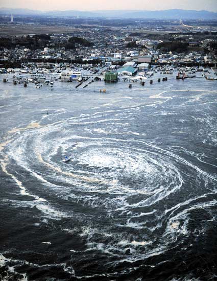Sebuah perahu tampak terjebak di pusaran air Gempa Tsunami Jepang 2011