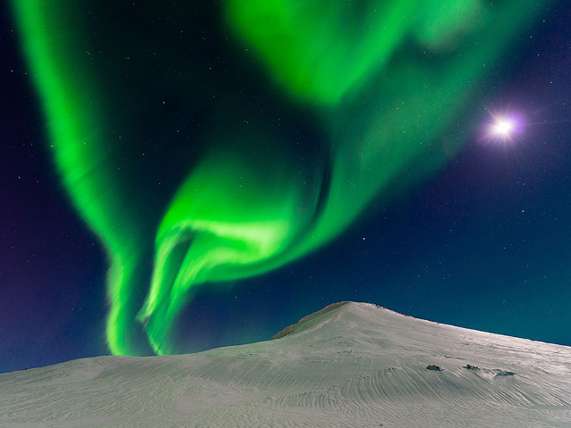 'Dancing With the Moon' fenomena alam cahaya hijau aurora dengan sinar bulan di Islandia. (kredit foto: National Geographic/Andrew George)