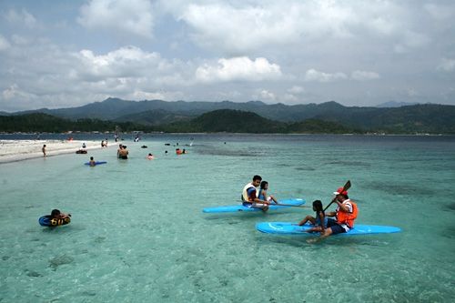 Pengungjung yang sedang menikmati air laut di Pantai Mutun Lampung.