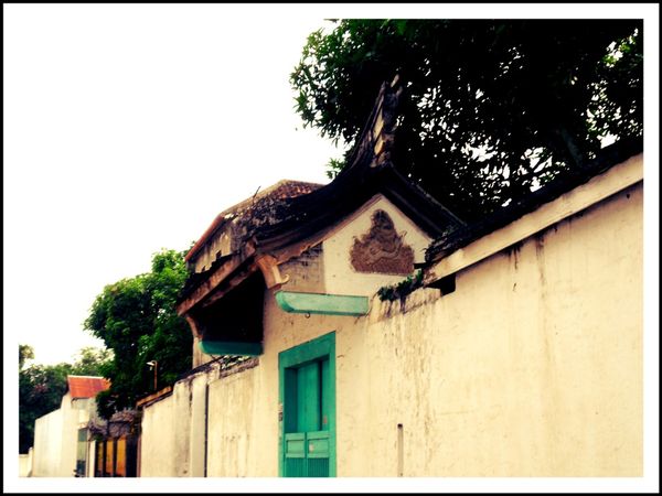 Deretan tembok tinggi yang memagari rumah-rumah tua bergaya peranakan