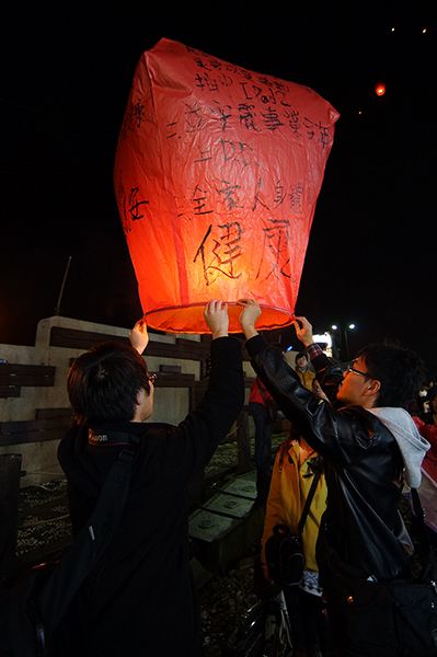 Sesaat sebelum diterbangkan, lampion dipegang bersamaan