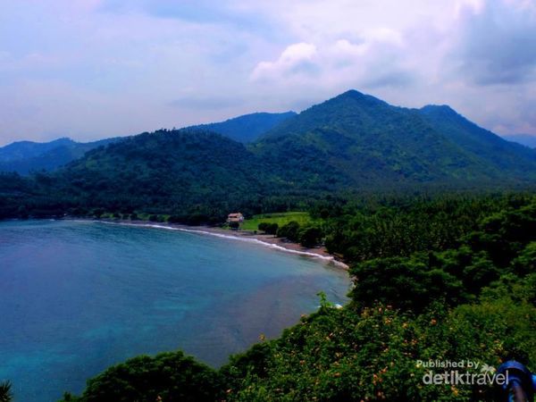 Panorama khas pantai barat Pulau Lombok: laut yang biru berkilau, pantai Malimbu yang berpasir putih,  kebon kelapa di sisi pantai, dan latar perbukitan yang kehijauan. 