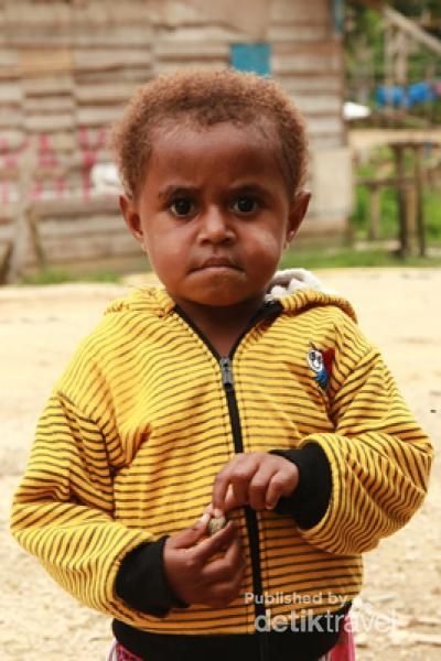 Dengan sedikit malu dan canggung, anak ini berpose di depan kamera