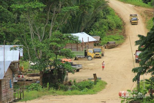 Pemukiman pekerja di distrik Sikame tampak dari atas. Seorang ibu menggendong anaknya berjalan menyusuri jalan setapak.