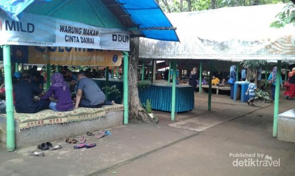Area tempat makan lesehan yang dikelilingi hutan dan sungai yang mengalir