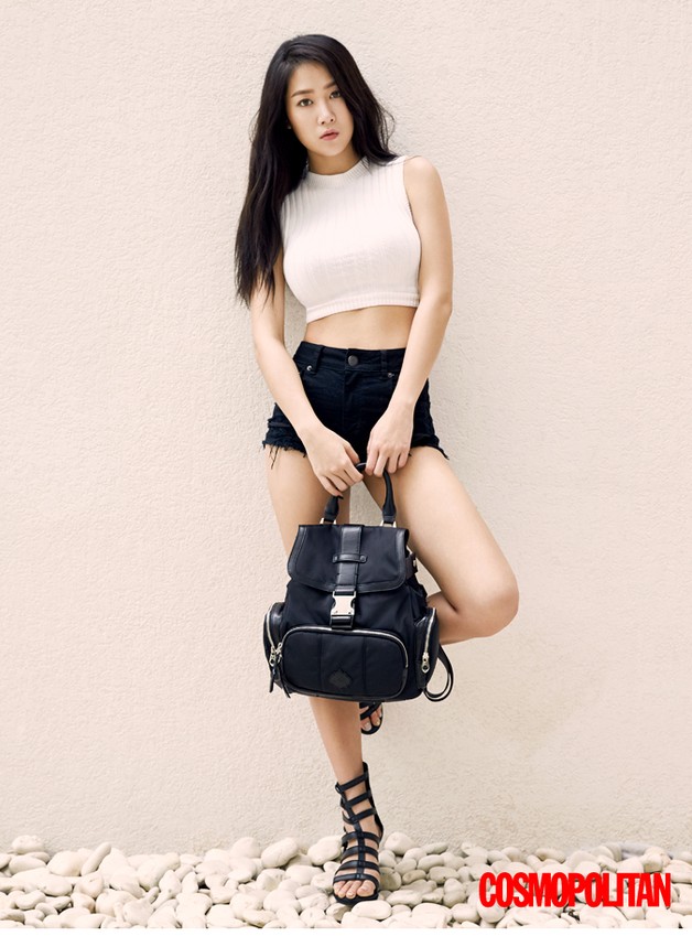 Berpose sambil memegang tas hitam, Soyu tampak seksi dengan crop top putih, hot pants hitam dan sandal gladiator hitam. (dok. Cosmopolitan Korea)