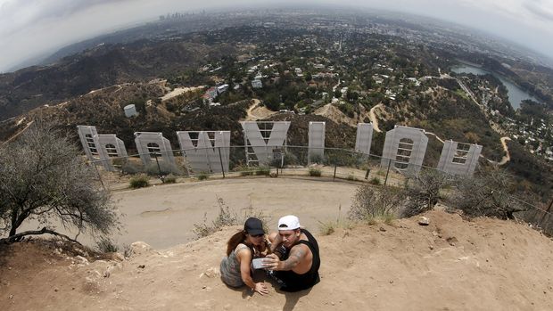 Pengunjung berfoto di dekat tanda Hollywood, yang lokasinya berbahaya.