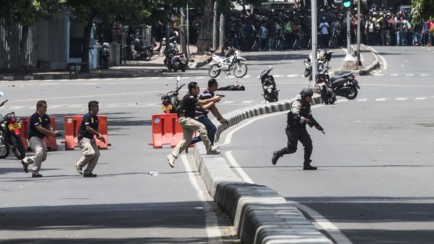 Petugas kepolisian berlari menuju ke arah gedung Sarinah untuk melakukan pengejaran terhadap pelaku penyerangan yang dilakukan sejumlah teroris ke beberapa gedung dan pos polisi di Jakarta, Kamis (14/1).