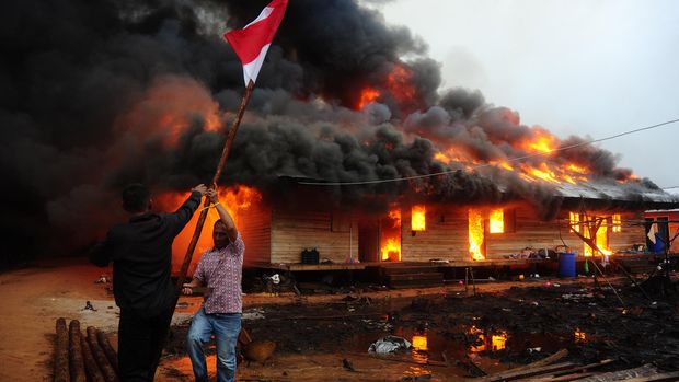 Dua orang melepas tiang bendera di lokasi permukiman warga eks-Gafatar yang dibakar massa di kawasan Monton Panjang, Dusun Pangsuma, Desa Antibar, Mempawah Timur, Kabupaten Mempawah, Kalbar, Selasa Januari 2016. Permukiman di lahan seluas 43 hektar tersebut dibakar sejumlah oknum masyarakat sebelum 796 warga eks-Gafatar dievakuasi pemda setempat. (ANTARA FOTO/Jessica Helena Wuysang)