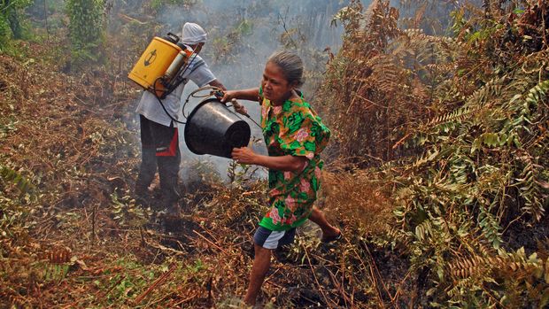 Sejumlah warga berusaha memadamkan api yang membakar kebun dengan alat seadanya di Desa Bokor, Kecamatan Rangsang Barat, Kabupaten Kepulauan Meranti, Riau, Selasa (15/3). (ANTARA FOTO/Rony Muharrman)