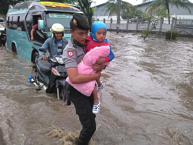 Ketika Polisi Gendong Anak-anak Terobos Genangan Banjir di Jalan Rancaekek