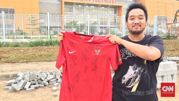Pendukung timnas memamerkan jersey bertandatangan pemain skuat Merah Putih jelang semifinal Piala AFF 2016 di Stadion Pakansari, Cibinong, 1 Desember 2016. (CNN Indonesia/M. Arby Rahmat)