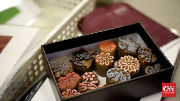 Batik geumbak khas Korea menggunakan alat cap dan lem untuk membuat pola emas di kain.