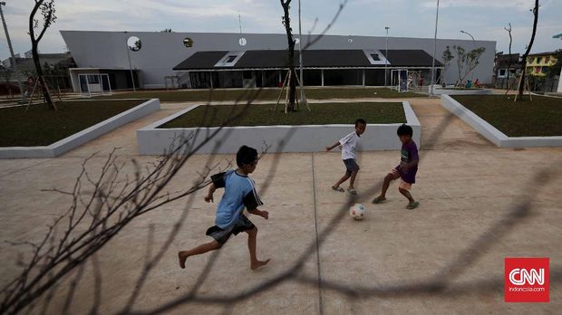 Tiga bocah bermain bola di Ruang Publik Terpadu Ramah Anak (RPTRA) Kalijodo.
