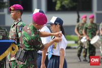 Penyematan tanda pelatihan kepada siswa SMP Labschool Kebayoran oleh Wakil Komandan Brigif 2 Korps Marinir. (CNN Indonesia/Deddy Sinaga)