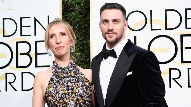 Aaron Taylor-Johnson menimang piala Golden Globes untuk Aktor Pendukung Terbaik.