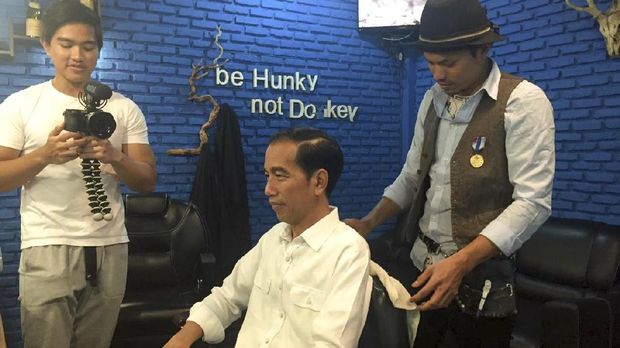 Presiden Joko Widodo tengah mencukur rambut di barbershop sembari ditemani sang anak, Kaesang Pangarep, Sabtu (14/1).