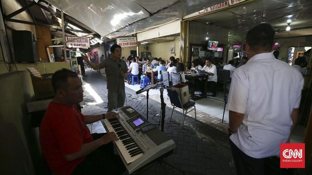 enyanyi menghibur warga yang bersantap siang di lapo yang berlokasi di belakang gedung DPR/MPR, Lapangan Tembak Jakarta, Kamis, 19 Januari 2017.