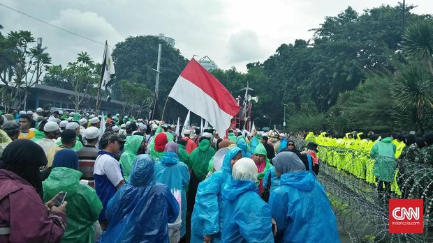 Aksi pendukung Rizieq Shihab diguyur hujan.