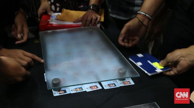 Petugas menutup 36 Kartu Tanda Penduduk (KTP) impor dari Kamboja dengan kaca saat rilis di Kantor Pusat Bea Cukai, Jakarta Timur.