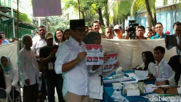 Sandiaga Uno dan istri mengambil kertas suara.