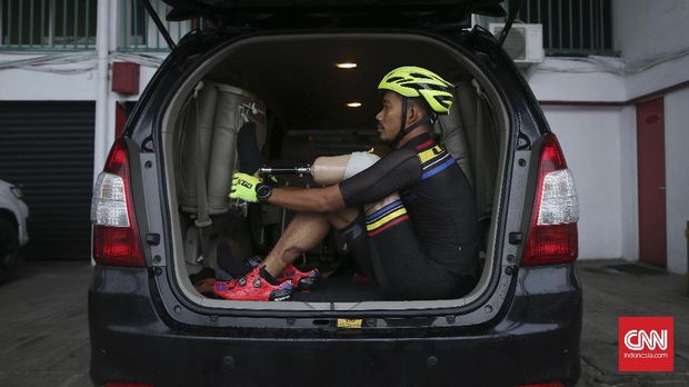 M. Fadly mengenakan sepatu kiri di bagian belakang mobil sebelum berlatih di Sirkuit Sentul.
