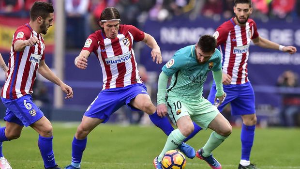 Lionel Messi tak dibiarkan bebas membawa bola di lini pertahanan Atletico Madrid.