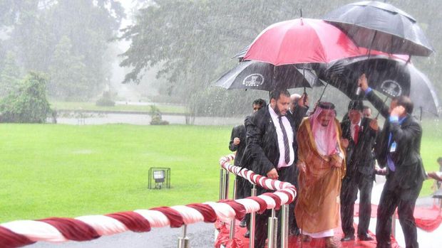 Saat Jokowi Memayungi dan Menggandeng Raja Salman