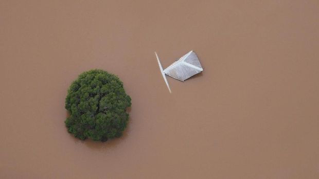 Hanya bagian atas pohon dan atap gedung yang terlihat di tengah banjir di kota Lismore, New South Wales