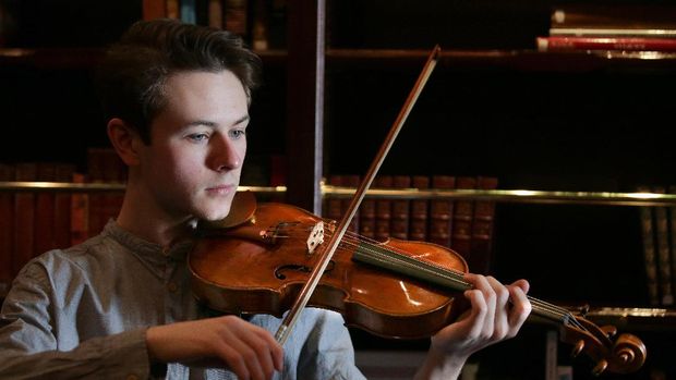 Samuel Staples ketika memainkan biola Stradivarius sebelum acara lelang di London.