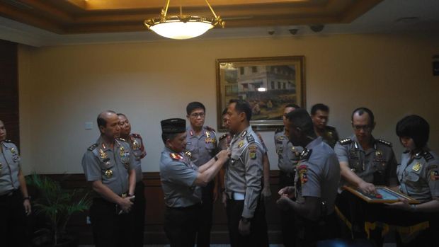 Kapolri menyematkan pin emas untuk Aiptu Sunaryanto.