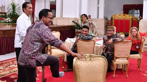 Seorang wartawan menunjukkan kaus kakinya bolong kepada Jokowi sebelum menerima hadiah sepeda. (Biro Pers Setpres/ Laily Rachev)