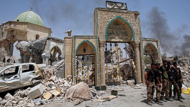 Tentara Irak merayakan kemenangan atas ISIS di Mosul, meski bangunannya sudah berantakan.