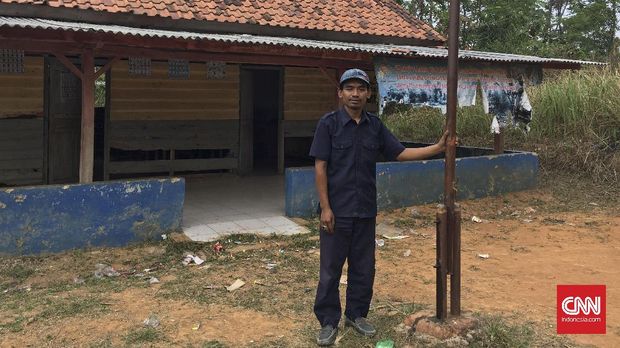 Atim Suryadi (35) di depan SD Mulyasejati IV, tempat ia mengajar di dusun Sukamulya, Kabupaten Karawang