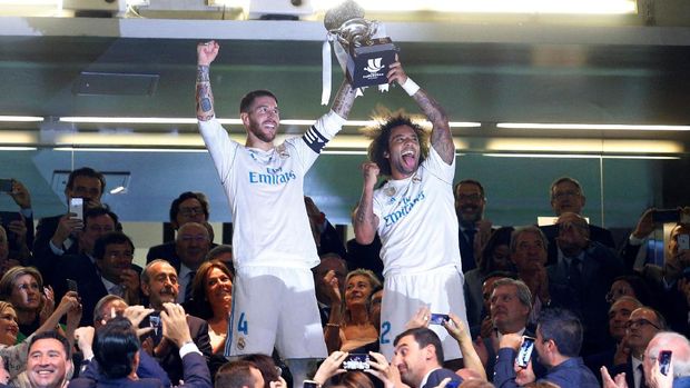 Sergio Ramos dan Marcelo mengangkat trofi Piala Super Eropa usai menekuk Barcelona dengan agregat skor 5-1. (