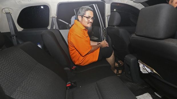Tersangka kasus dugaan ujaran kebencian di media sosial, Jonru Ginting (tengah) berjalan keluar dari ruang penyidikan dengan pengawalan petugas kepolisian usai menjalani pemeriksaan lanjutan di Ditreskrimsus Polda Metro Jaya, Jakarta, Minggu (1/10).