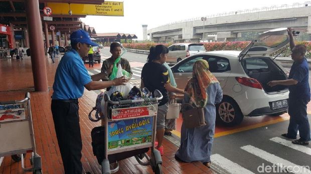 Sukri saat membantu penumpang di Soetta