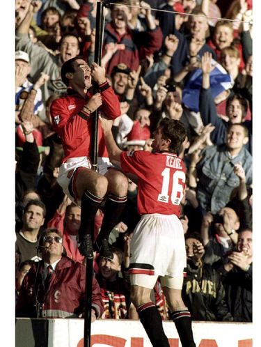 Eric cantona memanjat tiang setelah mencetak gol ke gawang Liverpool.