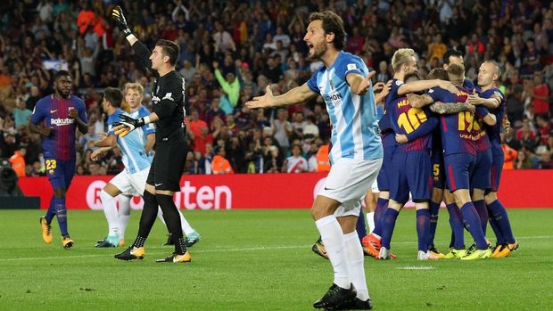 Pemain-pemain Malaga melakukan protes kepada wasit atas gol pertama Barcelona yang dicetak Gerard Deulofeu.