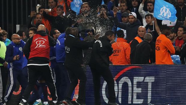 Suporter Olympique Marseille melemparkan berbagai barang ke arah lapangan dalam pertandingan antara Marseille dan PSG.