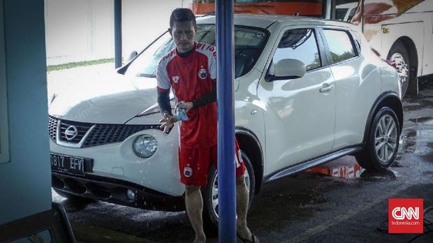 Ismed Sofyan memanfaatkan waktu senggang mencuci mobilnya. (