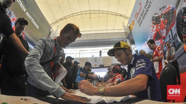 Valentino Rossi meladeni para fan yang meminta tanda tangannya. (