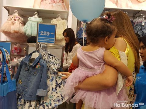Ibu-ibu sedang belanja baju anak/