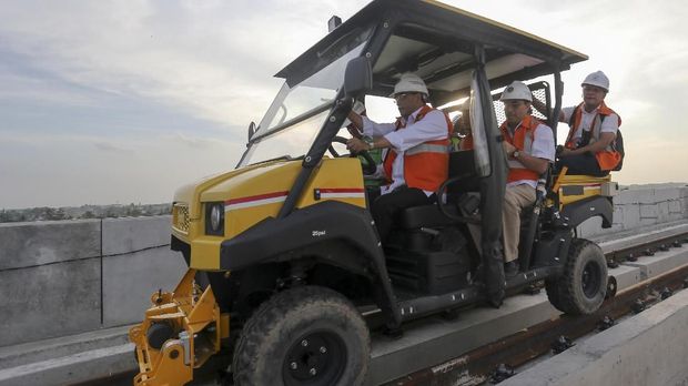 Menteri Perhubungan Budi Karya Sumadi (kedua kiri) didampingi Staff Khusus Kementrian PUPR Firdaus (kedua kanan) mengendarai lori saat meninjau progres pembangunan LRTdi Palembang.