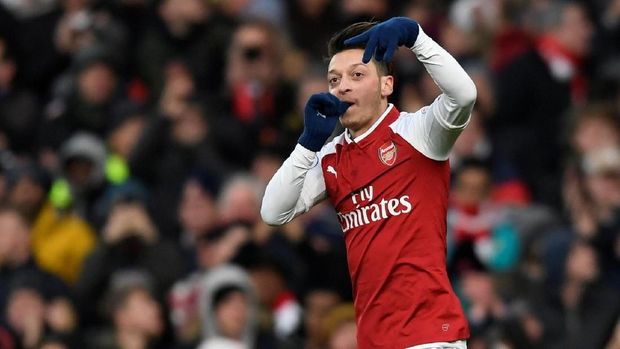 Tendangan voli Mesut Oezil tak mampu diantisipasi kiper Rob Elliot.