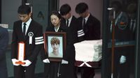 Para personel SHINee mengangkut peti mati Jonghyun.