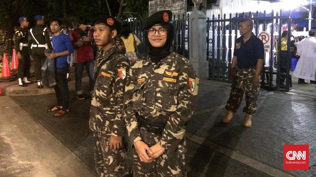 Di antara para personel Banser, ada dua perempuan yang ikut membantu pengamanan.