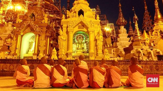Biksu-biksu cilik yang tengah berdoa di hadapan Buddha di Shwedagon Pagoda.