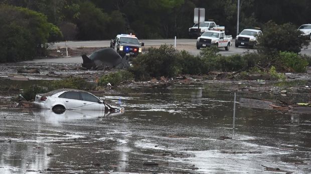 Sebuah mobil terbenam di lumpur akibat longsor di California, Selasa (9/1)