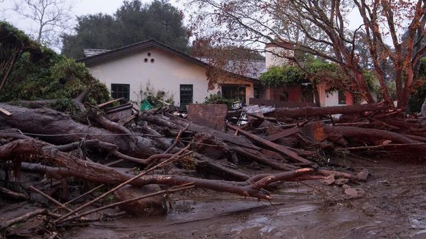 Sebuah rumah dikepung lumpur dan sampah-sampah yang dibawa longsor di California, Selasa (9/1)